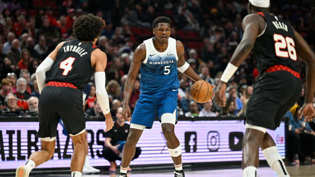 Feb 15, 2024; Portland, Oregon, USA; Minnesota Timberwolves guard Anthony Edwards (5) dribbles the ball during the first half against Portland Trail Blazers guard Matisse Thybulle (4) and center Duop Reath (26) at Moda Center.